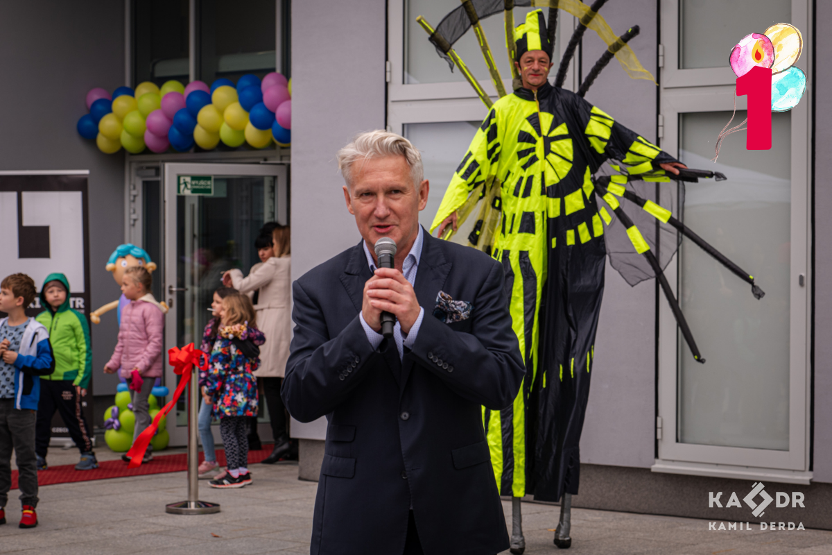 dyrektor teatru Robert CZechowski stoi przed Teatrem Lalek i mówi do mikrofonu